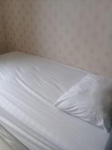 an unmade bed with white sheets and a pillow at Brand new and sweet @ apartemen parahyangan residence bandung in Bandung