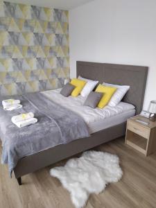 sypialnia z dużym łóżkiem z żółtymi poduszkami w obiekcie Apartament KAOLA w Jeleniej Górze