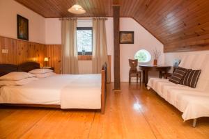 a bedroom with two beds and a table in it at Holiday Farm Grofija in Ivančna Gorica