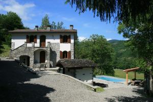 a house with a swimming pool in front of it at B&B Casale delle farfalle in Tornolo