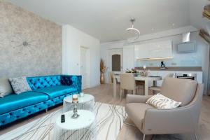 a living room with a blue couch and a kitchen at La Mer Penthouse in Varna City