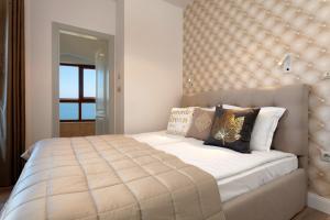 a bedroom with a large bed with a large headboard at La Mer Penthouse in Varna City +10 photos