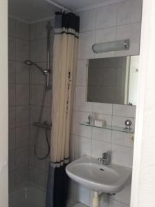 a bathroom with a sink and a shower at Hotel Pension Oranje in Valkenburg