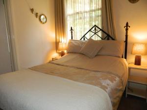a bedroom with a bed with two lamps and a window at Stoneway Guest House in Bridgnorth