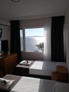a bedroom with two beds and a large window at VİLLA FUAT in Erdek