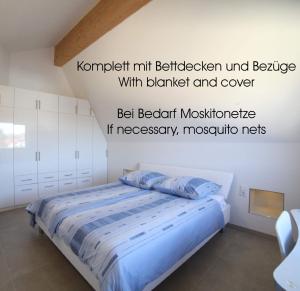 1 dormitorio con 1 cama con sábanas azules en Passivhaus 750m vom Bodensee -- 2x E-bike inklusive -- Neubau 2019 am Ortsrand en Öhningen
