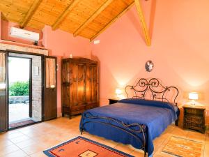 a bedroom with a bed with a blue bedspread at Fontana del Cherubino in Santa Maria di Licodia