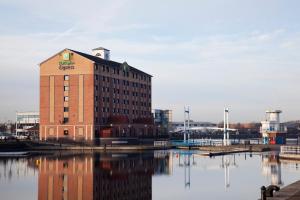 a large brick building next to a body of water at Holiday Inn Express Manchester - Salford Quays, an IHG Hotel in Manchester