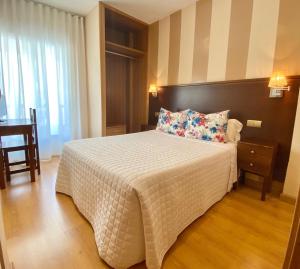 - une chambre avec un grand lit et une couette blanche dans l'établissement Hotel Fernando IV, à Martos