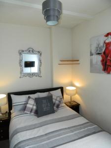 a bedroom with a bed with two lamps and a mirror at Stoneway Guest House in Bridgnorth