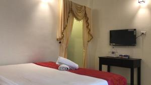 瓦卡拉的住宿－SUN VIEW Beach Resort By Citrine，一间卧室配有一张带电视的床和一张四柱床。