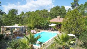 uma imagem de uma casa com piscina em Les Mille Mimosas em Les Assions