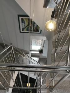 una scala a chiocciola con ringhiera di metallo e dispositivo di illuminazione di Apartman Fenjer a Zagabria
