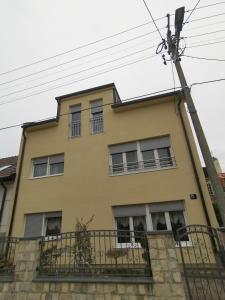 una casa amarilla con ventanas y un poste en Apartman Fenjer, en Zagreb