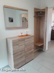 a bathroom with a wooden vanity with a mirror at Haus Am Peenestrom in Peenemünde