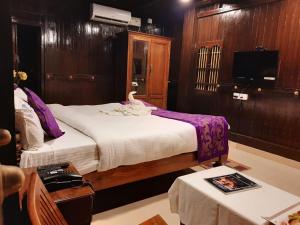 a hotel room with two beds and a television at SUN VIEW Beach Resort in Varkala