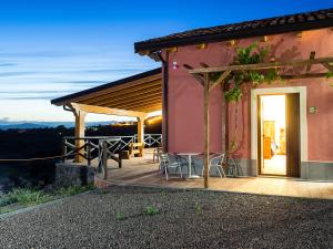 una casa con terrazza arredata con tavolo e sedie di Fontana del Cherubino a Santa Maria di Licodia