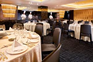 a restaurant with white tables and chairs and two chefs at ANA Crowne Plaza Hotel Kyoto by IHG in Kyoto