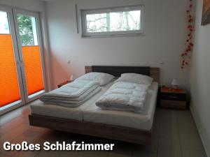 a bedroom with two beds and two windows at Haus Am Peenestrom in Peenemünde