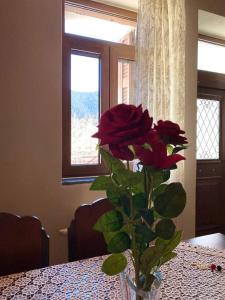 a vase with a red rose sitting on a table at Tzelati Vytinas in Vitina