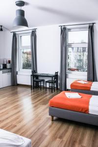 a bedroom with two beds and a table with a dining room at Apartamenty Babina in Kalisz