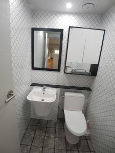a bathroom with a toilet and a mirror and a sink at Yong Stay in Jeju