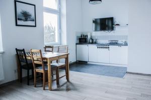a kitchen and dining room with a table and chairs at Apartamenty Babina in Kalisz