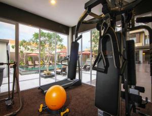 einen Fitnessraum mit orangefarbenem Ball und Trainingsgeräten in der Unterkunft The Kana Kuta Hotel in Kuta