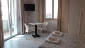 una camera con letto, tavolo e sedie di Depandance Macchiavelli 2 a Cagliari