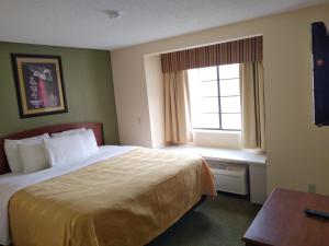 a hotel room with a bed and a window at Quality Inn & Suites in Prestonsburg
