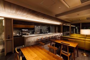 a restaurant with wooden tables and a bar at KéFU stay & lounge in Kyoto