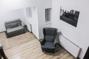 a waiting room with a chair and a couch at Pokoje Babina in Kalisz