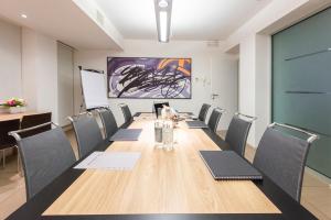 una sala conferenze con un lungo tavolo e sedie di Hotel Dimorae Rooms and Suites - Apartments a Civitanova Marche