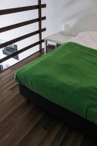 カリシュにあるPokoje Babinaのベッドルーム(緑のベッド1台、テーブル付)