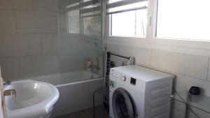 a bathroom with a washing machine and a sink at Studio face à la mer in Concarneau +49 photos
