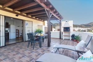 a patio with a table and chairs and a fireplace at Caballo de Mar Frison Cabo de Gata in San José