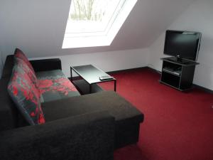 a living room with a couch and a tv at Ferienwohnung in Düsseldorf Hassel in Düsseldorf
