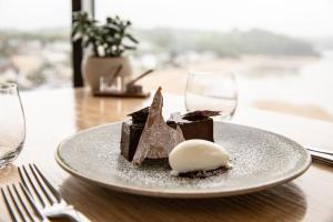 un postre en un plato en una mesa con copas de vino en St Brides Spa Hotel & Village Apartments, en Saundersfoot