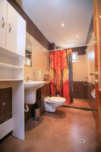 a bathroom with a toilet and a sink and a shower at Апартаменти Мери in Sandanski