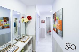 Jest to biały pokój z biurkiem i lustrem. w obiekcie My Sweet Red Apartment w mieście Benidorm