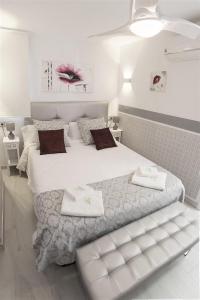 biała sypialnia z dużym łóżkiem i ręcznikami na nim w obiekcie My Sweet Red Apartment w mieście Benidorm +37 zdjęć