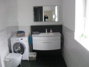 a bathroom with a sink and a washing machine at Bella Colonia Vieren in Hürth