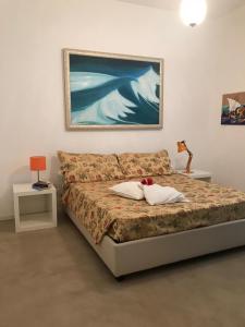 Schlafzimmer mit einem Bett mit Wandgemälde in der Unterkunft Casa Viansa in Favignana