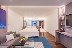 a hotel room with a bed and a couch at Oceanfront Beach Resort - SHA Extra Plus in Patong Beach