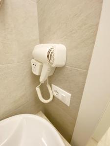 ein Bad mit einem WC und einem Ventilator an der Wand in der Unterkunft B&b Tre Perle in Gallipoli