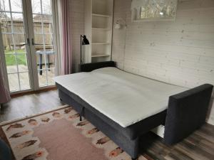 uma cama num quarto ao lado de uma janela em Stugan Brantevik em Brantevik