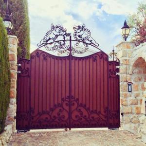 a red gate with two cats on top of it at Chambres chez l'habitant Villa l'Île aux Anges in Saint-Andre-de-la-Roche