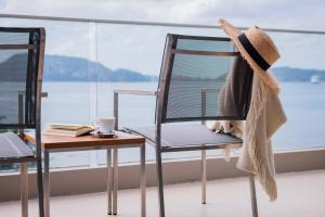 a hat sitting on a chair next to a table at Oceanfront Beach Resort - SHA Extra Plus in Patong Beach