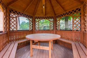 a wooden table in the center of a gazebo at POKOJE u JÓZKA w Polańczyku nad Jeziorem Solińskim in Polańczyk