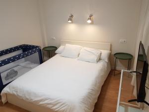 - une chambre avec un lit blanc et deux tabourets dans l'établissement PLAYA RINCON DE LA VICTORIA, à Rincón de la Victoria